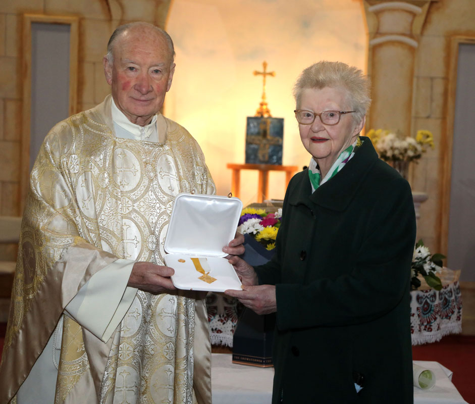 Canon Joe Feeney AP Kiltullagh, presents the Bene Merenti medal to Josie Costello in recognition of her outstanding service as sacristan of St Patrick's church, Cloonfad, on February 17th, 2025.